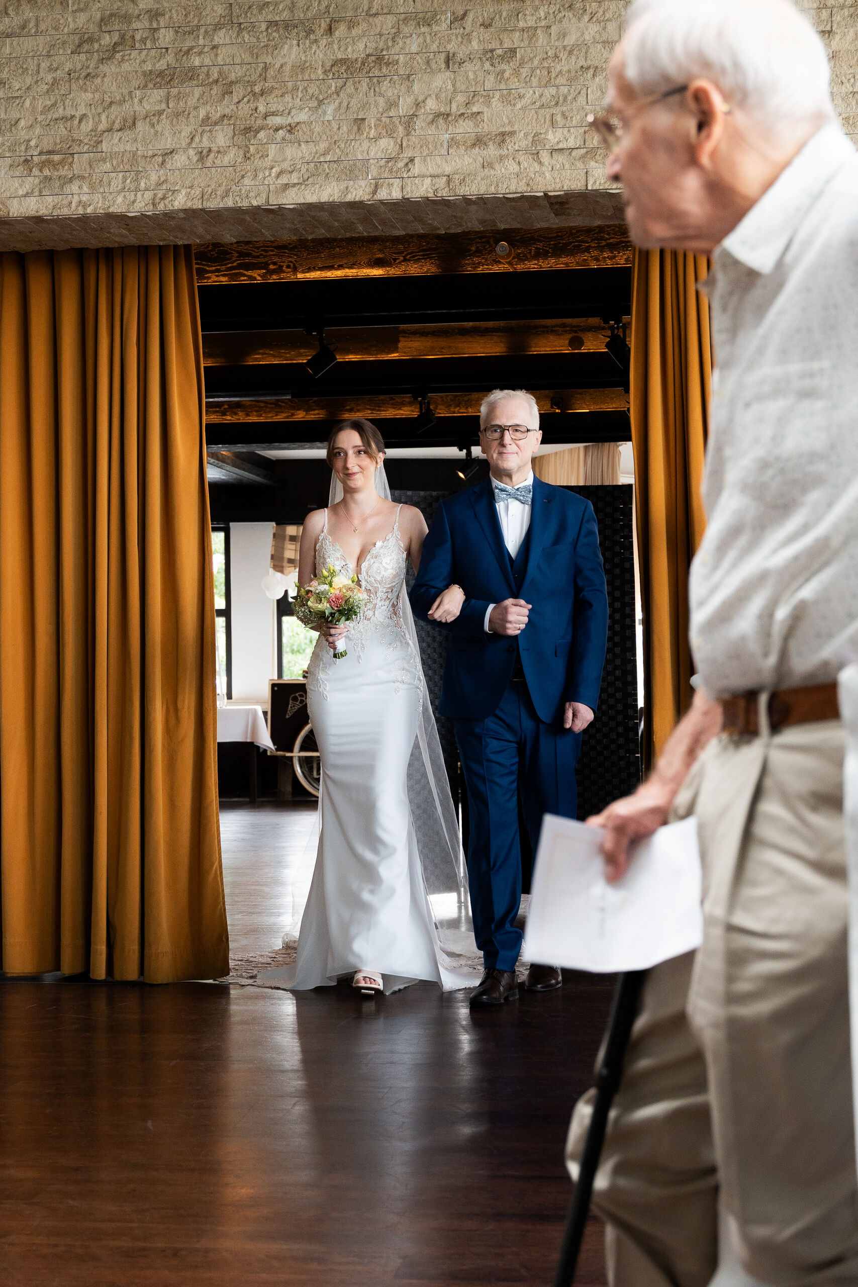 Einzug der Braut mit ihrem Vater durch den Vorhang in den Saal