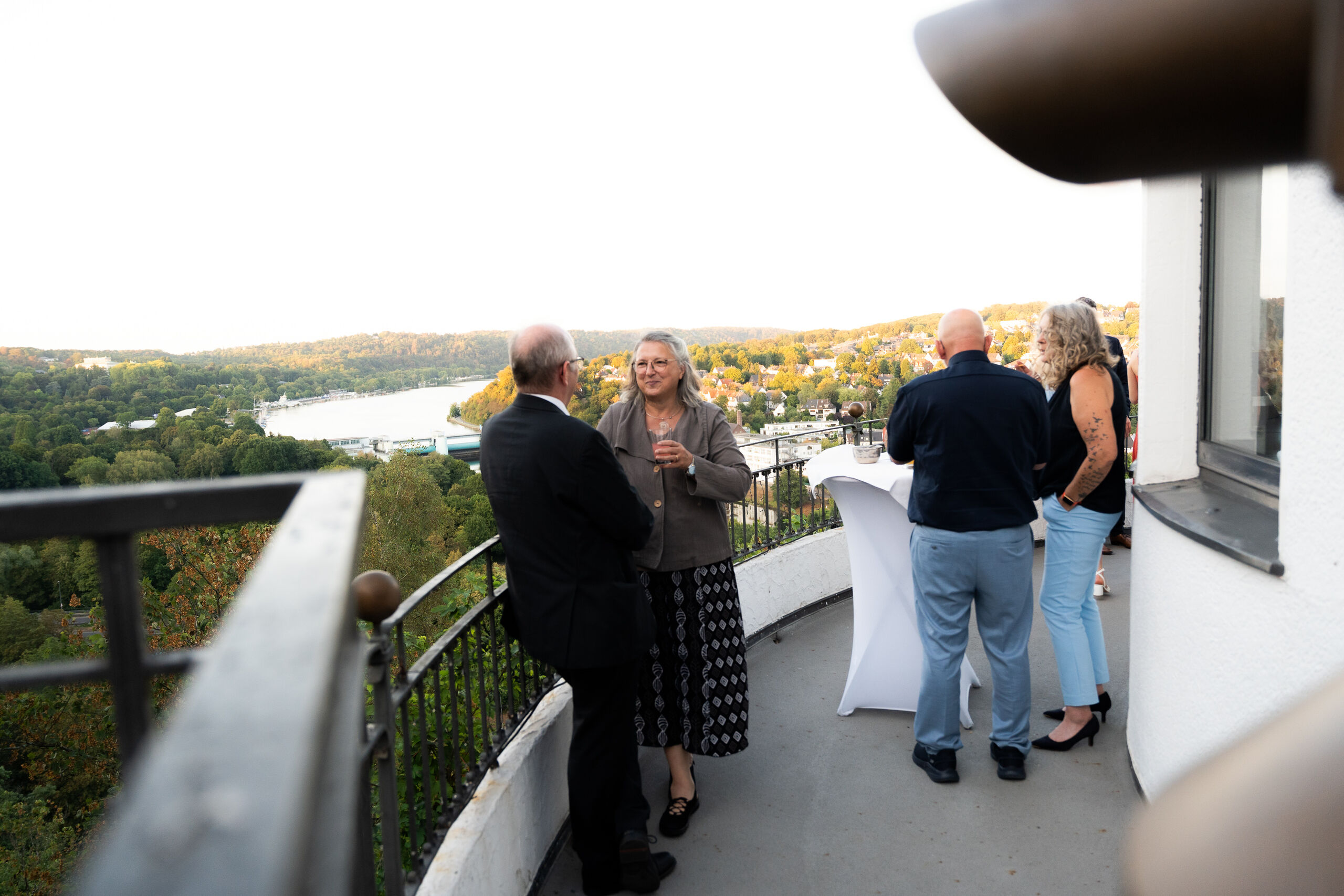 Gäste beim Empfang auf dem Balkon der Villa Vue im Abendlicht